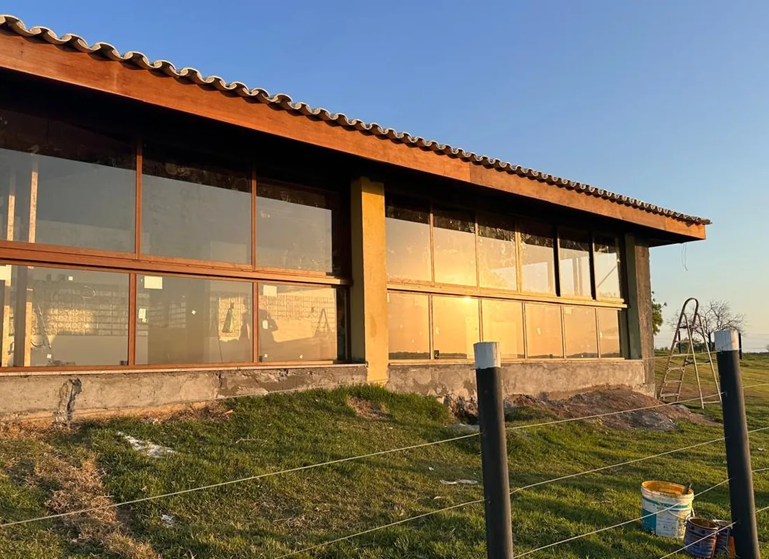 Haras Belo Vale: fechamento em vidro e madeira à beira do lago
